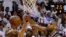 El jugador de Spurs Tim Duncan (d) bloquea un lanzamiento de LeBron James (c), de Heat,  durante el primer partido por la final de la NBA en el American Airlines Arena de Miami, Florida