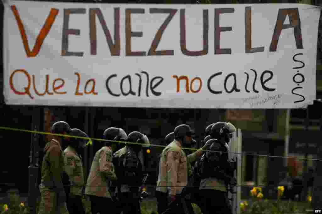 Un grupo de manifestantes se defienden de la policía durante una protesta