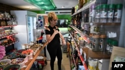Una mujer mira las etiquetas de precios dentro del comercio privado KO Mercado, en La Habana, el 24 de junio de 2026.