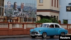 Una valla con la imagen del fallecido dictador cubano Fidel Castro, su hermano Raúl Castro y y el gobernante Miguel Díaz-Canel, en una calle de La Habana.