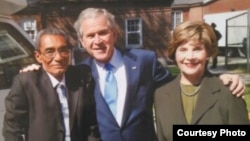 El exprisionero político Omar Pernet junto al expresidente George Bush y la esposa de éste, Bárbara.