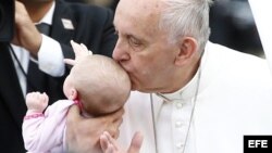 El papa Francisco besa a un bebé durante su visita al Independence Mall, en Filadelfia.