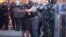 Policía abraza a uno de los manifestantes que ayudó a dispersar la multitud en Atlanta. AP Photo/John Bazemore