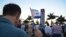 David Acosta sostiene una bandera cubana durante la vigilia contra el diálogo entre EEUU y Cuba celebrada en el Memorial Cubano de Miami. 