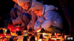 Unos niños encienden unas velas junto a las tumbas de los padres del último Papa de la Iglesia Católica, el fallecido Juan Pablo II.