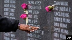 Una mujer deja una ofrenda en el Korean War Memorial en Filadelfia el Día de los Veteranos, viernes 11 de noviembre de 2022. (AP Photo/Matt Rourke).