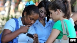 Jóvenes utilizan sus teléfonos celulares. 