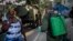 Un soldado de las fuerzas armadas usa una máscara como protección mientras limpia una calle con solución de cloro en La Habana. . (AP/Ramon Espinosa) 