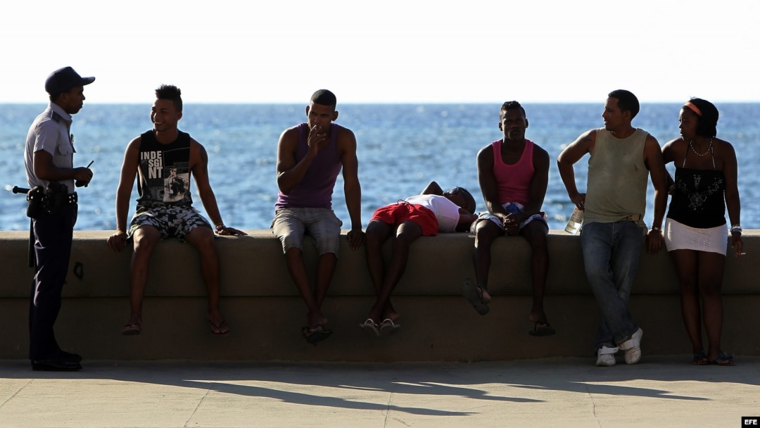 Un policía junto a varios jóvenes en el malecón de La Habana (Cuba). Foto Archivo.
