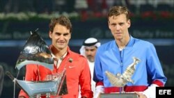 Roger Federer (i) y Tomas Berdych (d) posan con sus trofeos.
