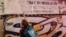 Activistas cubanos borran con pintura carteles en Santiago de Chile que celebran el centenario del natalicio de Fidel Castro. (Captura de video de @AngelRCuba/X) 