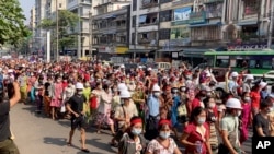 En esta imagen tomada de un video, una multitud de manifestantes marchan por Yangón, Myanmar, el 6 de febrero de 2021. (AP Foto)