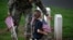 Un soldado y su hija colocan banderas en el Cementerio Nacional de Arlington, en Virginia, EEUU, en conmemoración del Día de los Caídos.