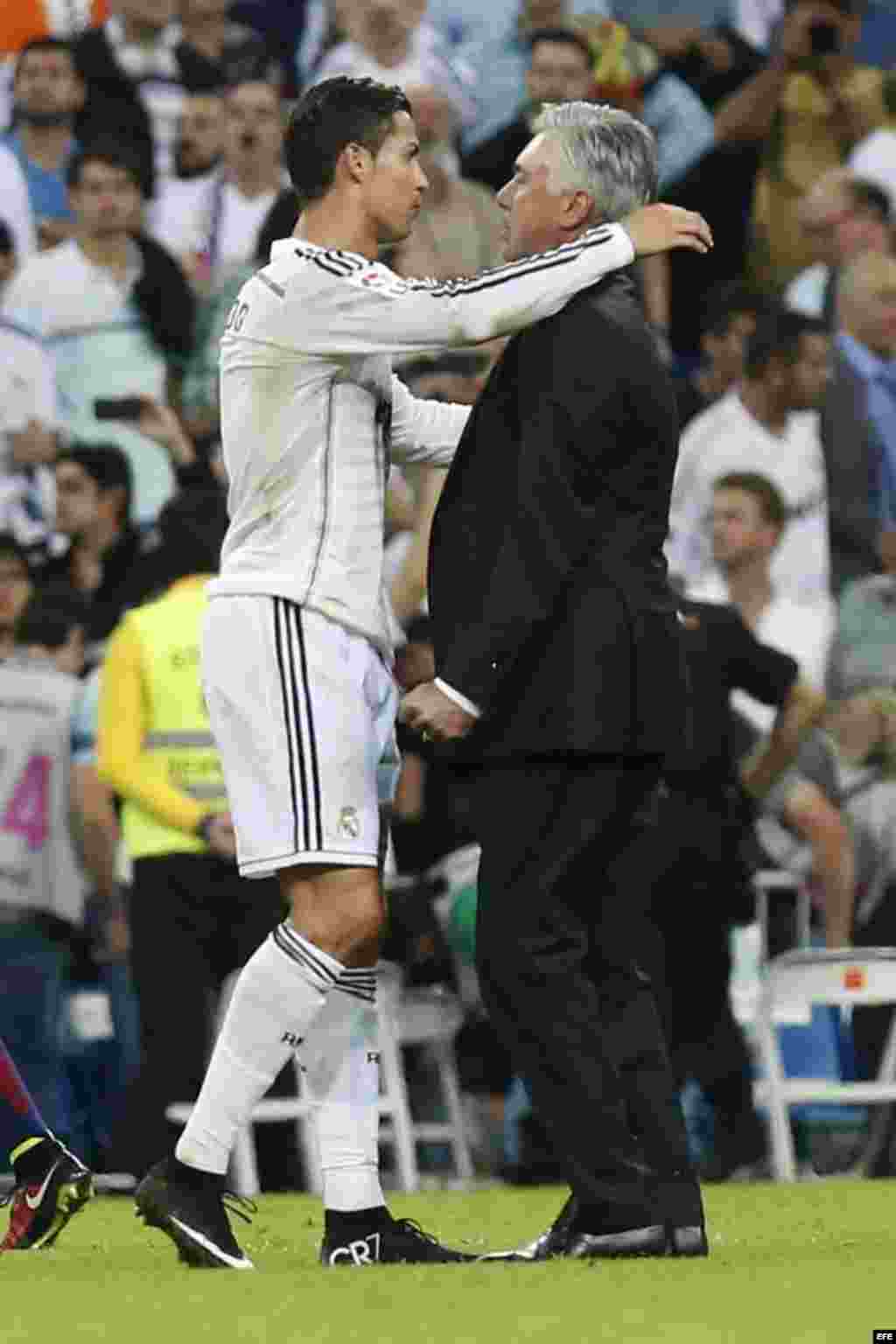 El delantero portugués del Real Madrid Cristiano Ronaldo (d) celebra con su entrenador, el italiano Carlo Ancelotti (d), la victoria ante el FC Barcelona. 