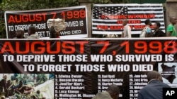 Carteles del público en Nairobi, Kenia, que piden no olvidar a las víctimas de los atentados terroristas de 1998. (AP Photo/Ben Curtis).