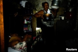Maria Rosa Ginarte organiza ollas y sartenes en su cocina mientras su esposo duerme durante un apagón en La Habana, Cuba, 10 de junio de 2026. REUTERS/Norlys Perez