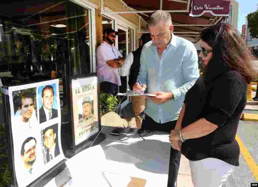 A la izquierda, el exiliado cubano Francisco Rodríguez, de la ciudad de Hialeah, firma la petición. A su lado, María A. Lima, del Directorio Democrático Cubano. (Foto: Roberto Koltun)