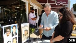 A la izquierda, el exiliado cubano Francisco Rodríguez, de la ciudad de Hialeah, firma la petición. A su lado, María A. Lima, del Directorio Democrático Cubano. (Foto: Roberto Koltun)