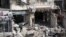 Varios combatientes del Ejército Libre Siro (ELS) rastrean un edificio en Alepo, Siria luego de bombardeos.