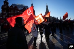 Seguidores del partido comunista ruso marchan con banderas rojas y flores hasta el mausoleo de Lenin, en el centenario de su muerte. (AP/Alexander Zemlianichenko)