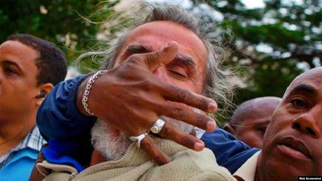 El periodista independiente cubano Agustín López Canino es acallado por agentes policiales de civil tras gritar "Vivan los Derechos Humanos".