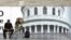 Un fotógrafo ambulante, de los conocidos popularmente como "minuteros", espera la llegada de algún cliente frente al Capitolio.
