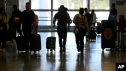 Los viajeros caminan por la terminal del Aeropuerto Internacional de Miami. (Foto AP/Lynne Sladky)