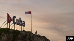Un hombre mira el cielo desde un cartel de Cuba, en La Habana. ADALBERTO ROQUE / AFP