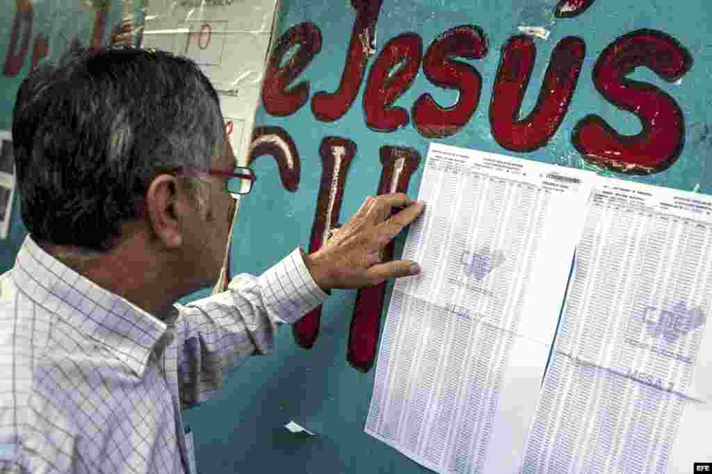Elecciones municipales en Venezuela. Un hombre busca su mesa de votación a la entrada de un colegio electoral en Caracas durante los comicios municipales hoy en Venezuela en los que 19 millones de venezolanos y residentes con más de diez años en el país están llamados a las urnas.