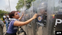 Los venezolanos se enfrentan a guardias nacionales y les piden que dejen pasar la ayuda humanitaria por el puente Simón Bolívar, en Cúcuta, Colombia, después de que el gobierno del presidente Nicolás Maduro ordenara un cierre temporal de la frontera con C