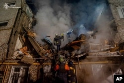 Operarios del departamento trabajan en un edificio de apartamentos destruido por un ataque ruso, en Sumy, Ucrania. (Servicio de Emergencias de Ucrania vía AP 13/03/2024 )