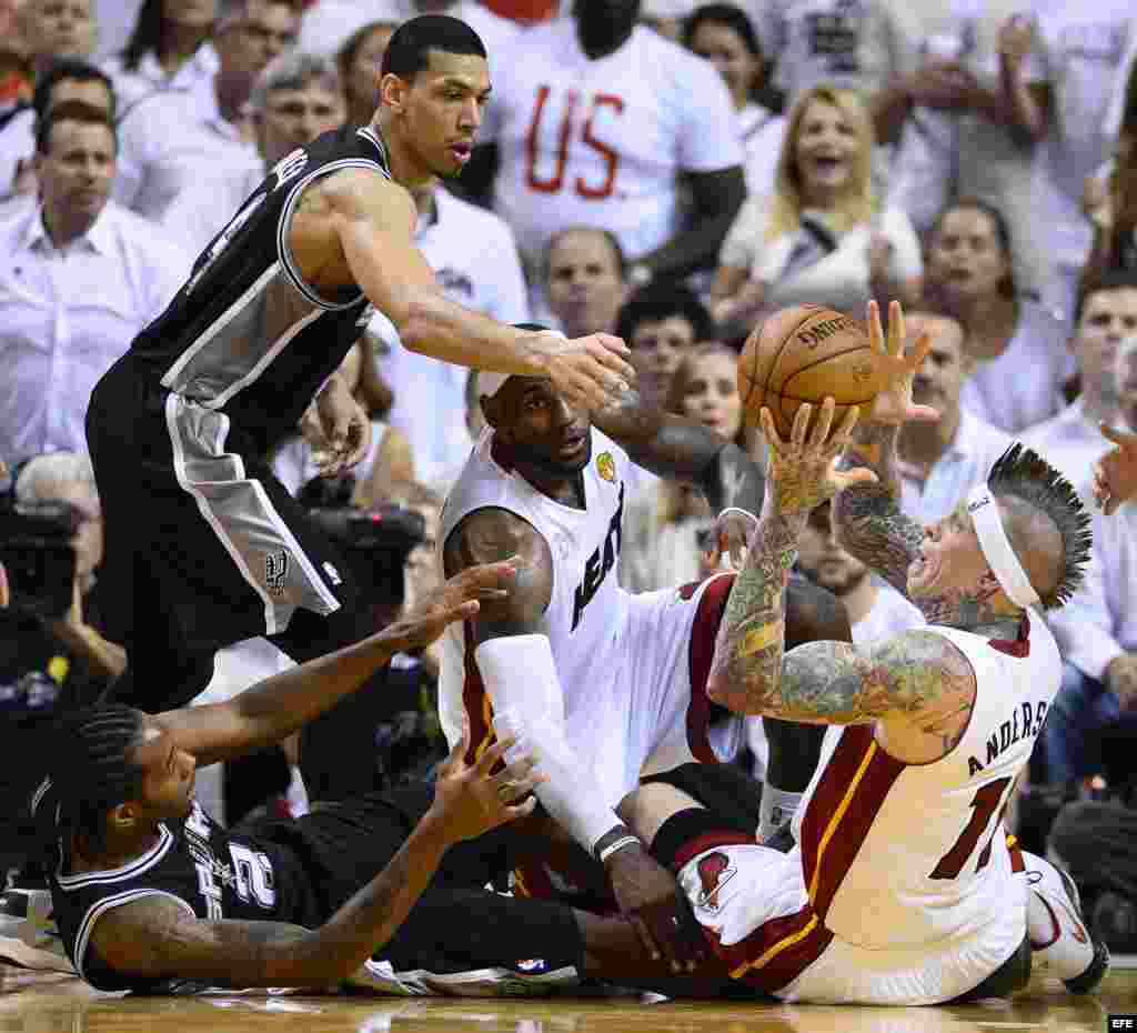 El jugador de Heat Chris Andersen (d) atrapa el balón ante la marca de KAwhi Leonard (i-abajo) y Danny Green (i), de Spurs, durante el partido definitivo de la serie final de la NBA. 