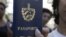 Una cubana muestra su pasaporte cubano obtenido en una oficina de Inmigración en La Habana, Cuba. 