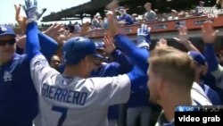 Alex Guerrero es recibido por sus compañeros tras batear como emergente un jonrón de dos carreras..