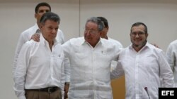  El presidente de Colombia, Juan Manuel Santos, el máximo líder de las FARC, Rodrigo Londoño, alias "Timochenko", y el presidente de Cuba, Raúl Castro, participan en el acto para presentar un acuerdo en los diálogos de paz en La Habana (Cuba).