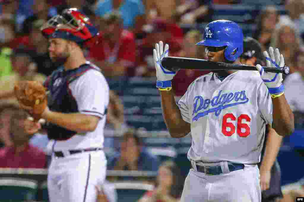 Yasiel Puig (d) de los Dodgers de los Ángeles muerde su bate en el partido ante los Bravos de Atlanta 