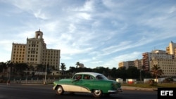 Un viejo automóvil circula por el malecón habanero. EFE/Archivo