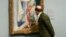 Hombre observando una pintura de Renoir