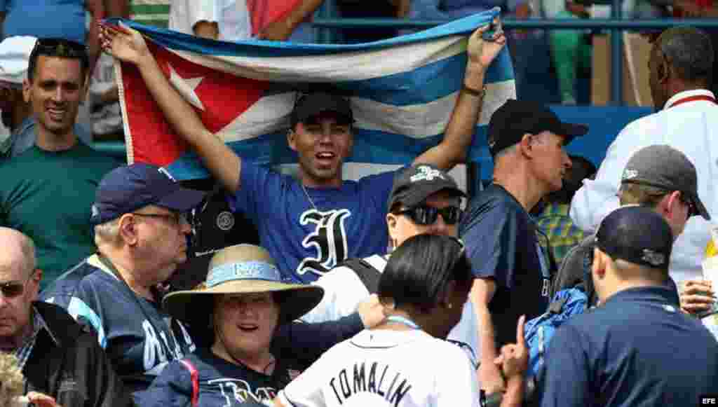 Un aficionado cubano con la camiseta de Industriales y la bandera cubana.