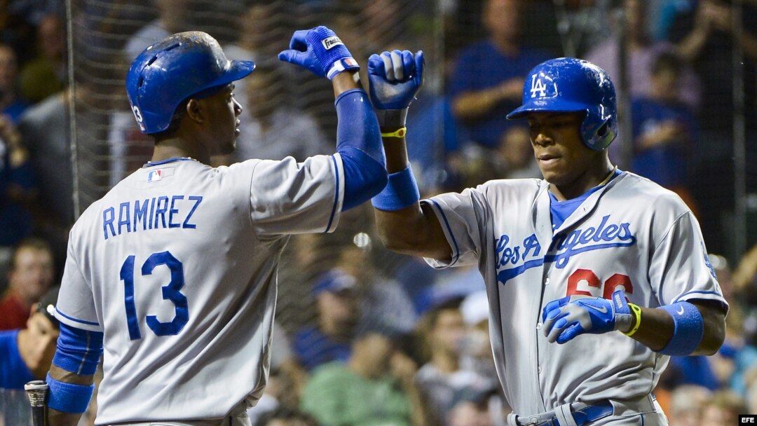 Hanley Ramírez (i) de los Dodgers de Los Ángeles felicita a Yasiel Puig (d) tras batear un jonrón ante los Cachorros de Chicago durante un partido de la MLB. 