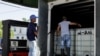 Cubanos llenan tanques con gasolina en un servicentro en La Habana. 
