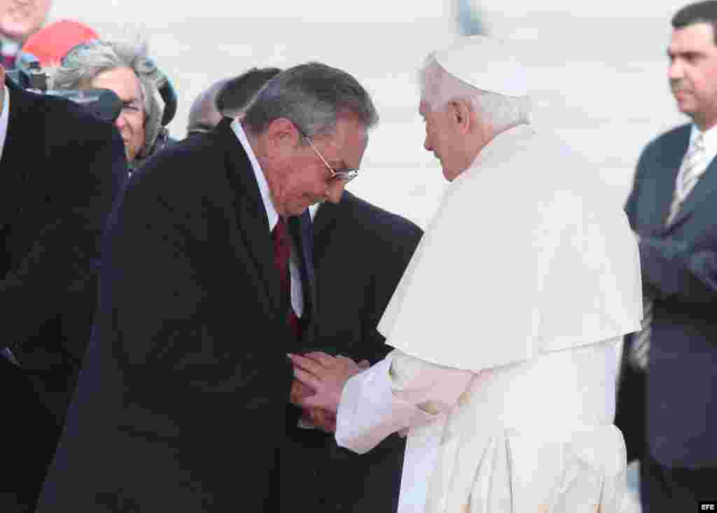 El papa Benedicto XVI (d) saluda a Raúl Castro el 26 de marzo de 2012, en el aeropuerto internacional de Santiago de Cuba.