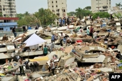 Voluntarios buscan entre los escombros de edificios colapsados en Caraballeda, La Guaira, Venezuela, el 3 de julio de 2026. La cifra de fallecidos por los dos terremotos ocurridos en Venezuela ha ascendido a 2.595. (Foto de MARTIN BERNETTI / AFP)