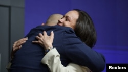 La líder opositora venezolana María Corina Machado abraza al activista cubano Lázaro Mireles durante una conferencia de prensa, como parte de su visita a España, en Madrid, España, el 18 de abril de 2026. REUTERS/Isabel Infantes
