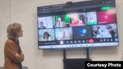 Elena Larrinaga escucha a participantes en el foro, que se realizó en formato híbrido: presencial y virtual.