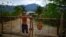 El campesino Javier Tamayo, 55, posa junto a su nieto en su casa en la Sierra Maestra. REUTERS/Alexandre Meneghini 