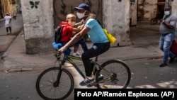 Un hombre transporta a un niño en bicicleta en La Habana. AP Photo/Ramon Espinosa