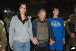 Judith Raanan (derecha) y su hija Natalie, de 17 años, escoltadas por soldados israelíes y por Gal Hirsch, coordinador para el regreso de los rehenes, a su regreso a Israel tras un cautiverio en la Franja de Gaza, el 20 de octubre de 2023. (Gobierno de Israel vía AP)