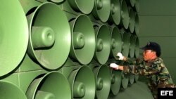 Fotografía de archivo tomada el 16 de junio de 2004 que muestra a un soldado surcoreano que retira altavoces de la zona desmilitarizada en Paju, al norte de Seúl. 