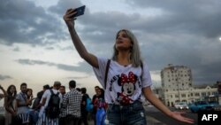 Una joven youtuber cubana graba un video en el Malecón habanero. 